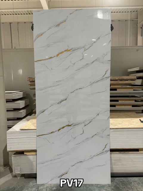 Large white marble-patterned tile with gray and gold veining, displayed in a showroom with model number PV17