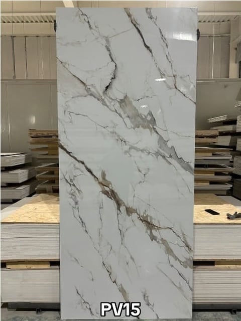 Marble tile sample labeled PV15 displaying white stone with gray and brown veining patterns