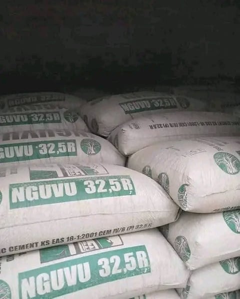 Stacked white cement bags with green NGUVU 32.5R labels and logo markings