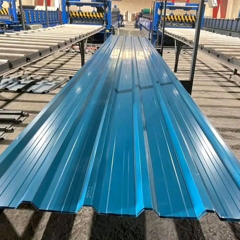 Blue corrugated metal roofing sheets lined up on a factory production line