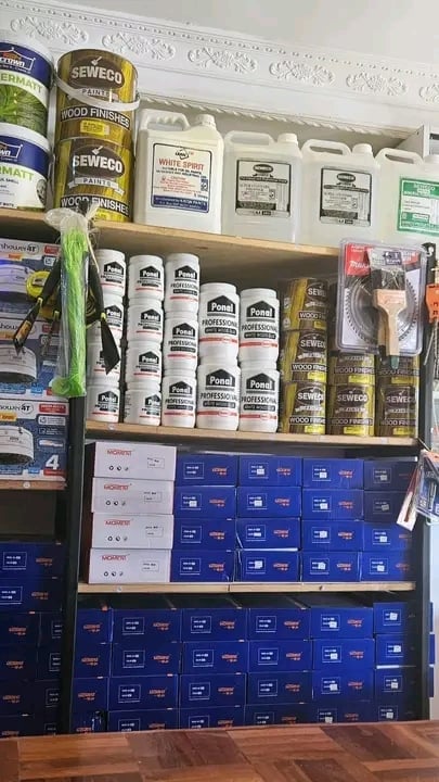 Retail display shelving stocked with various wood finishing products including Minwax stains, Sewing wood sealers, and packaged finishing supplies organized on multiple levels