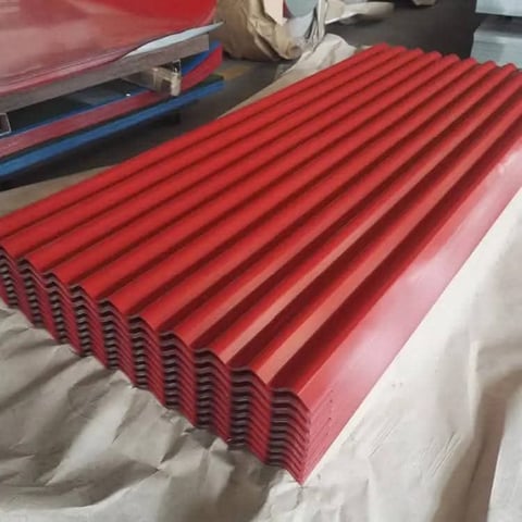 Stack of red corrugated metal roofing sheets displayed on white surface in warehouse setting