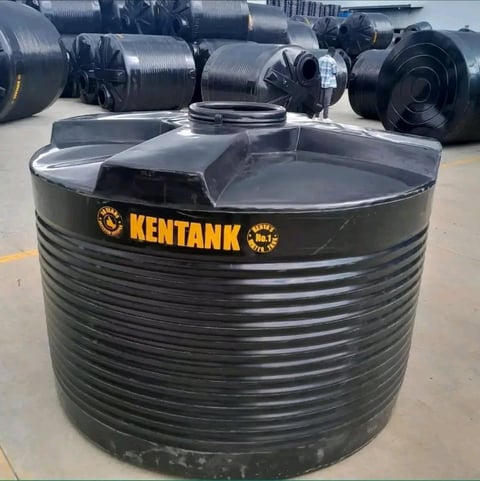 Large black KENTANK cylindrical water storage tank displayed at outdoor industrial facility with additional tanks visible in background