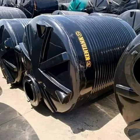 Black ribbed industrial storage tank with yellow branding on outdoor concrete surface