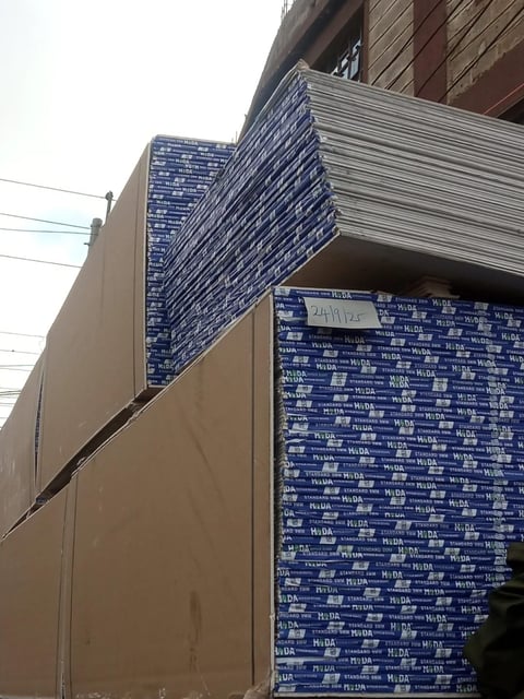 Construction site with blue branded sheathing covering building exterior and wooden framing visible above