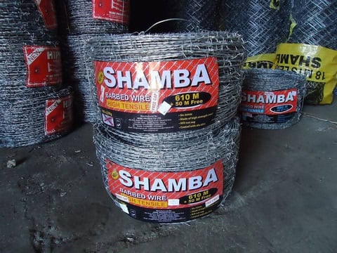 Rolls of Shamba branded barbed wire fencing stacked at a hardware store