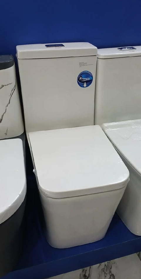 White Francis toilet on display with lid open against a dark blue background, showcasing modern bathroom fixture design