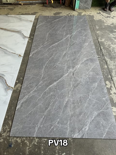 Gray marble or stone slab labeled PV18 on warehouse floor during installation or preparation