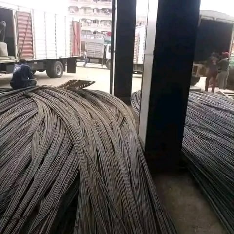 Large coils of steel reinforcement bars stacked in an industrial warehouse