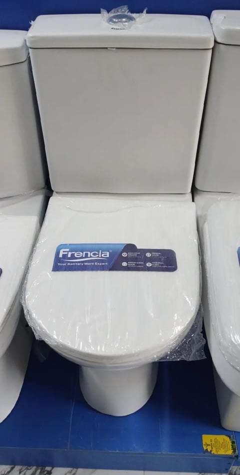 New Frencia white toilet with closed seat and tank displayed in showroom with plastic wrap