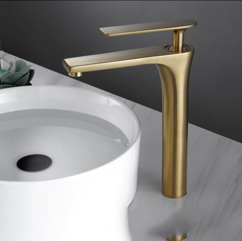 Gold single-handle tall bathroom faucet with white vessel sink on gray background