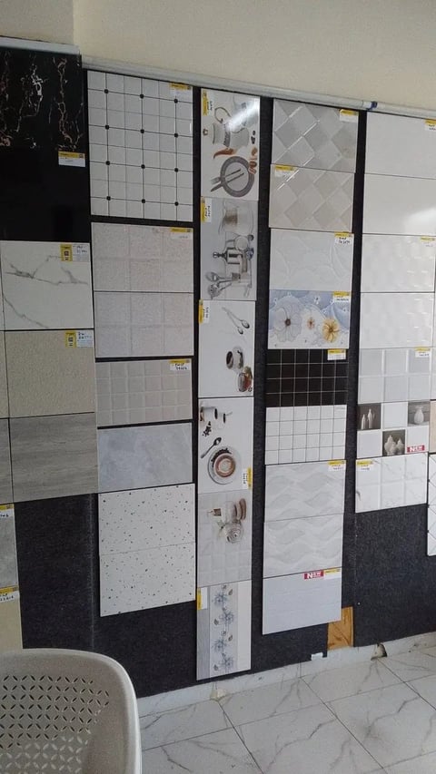 Tile showroom display with samples of various bathroom tiles, fixtures, and hardware mounted on vertical panels with price tags