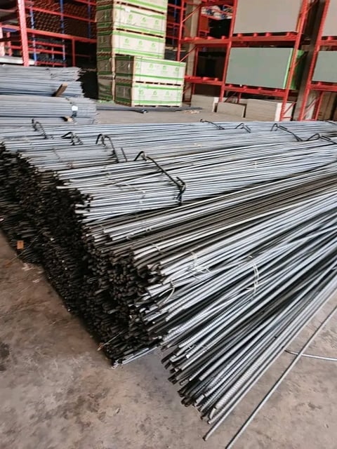 Stacked bundles of galvanized steel rebar in an industrial warehouse