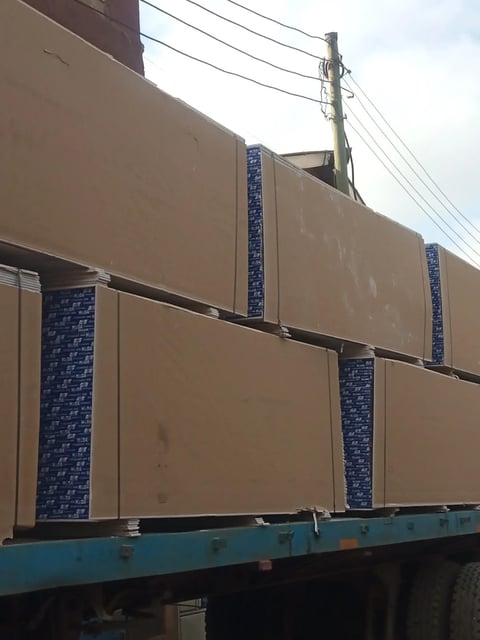Large cardboard boxes stacked on a blue truck bed with blue decorative padding between sections