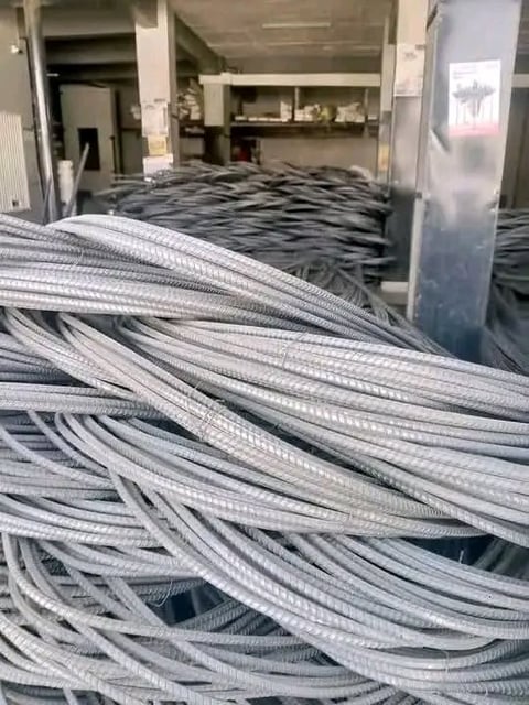 Coiled white and gray electrical cables stacked in an industrial warehouse