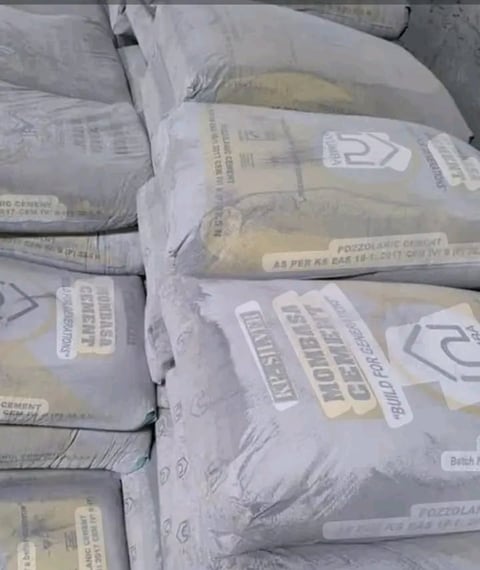 Stacked bags of white cement or concrete powder with printed labels and product information visible on packaging