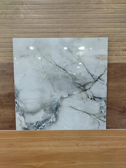 White marble tile with gray veining displayed on wooden floor