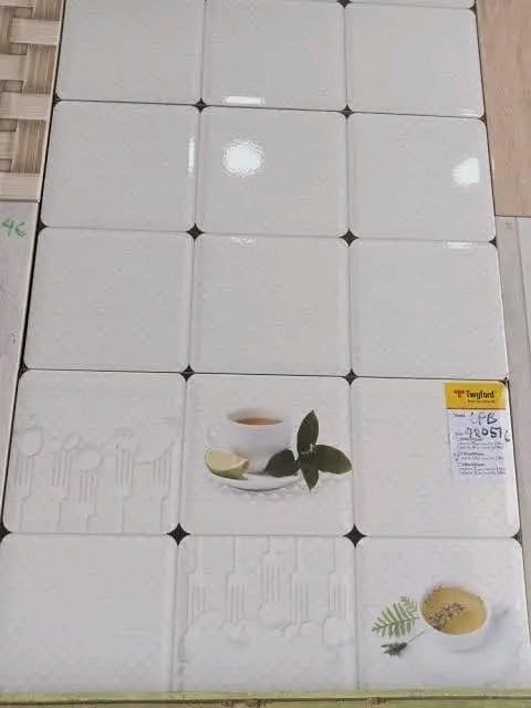Ceramic tile display showing white decorative tiles with botanical designs, featuring cups with herbs and plants as examples.