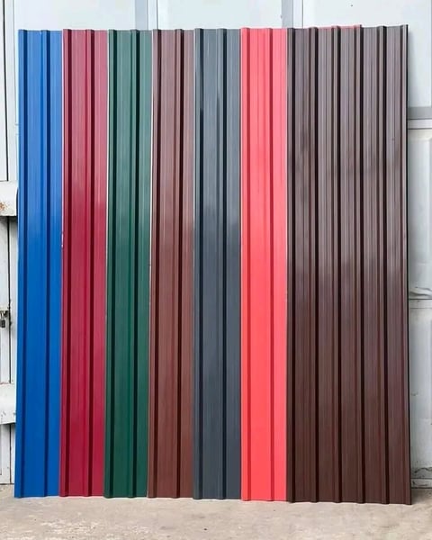 Display of corrugated metal roof panels in various colors including blue, red, green, brown, gray, and coral arranged side by side