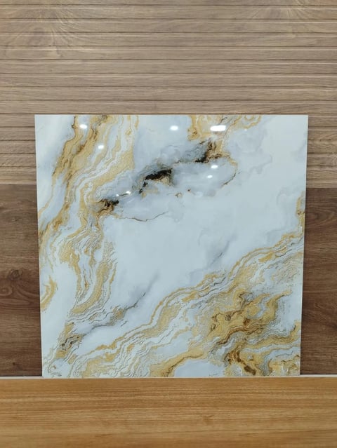 White and gold marble tile sample leaning against wooden wall background