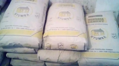 Stacked bags of Portland cement with beige and yellow packaging labels