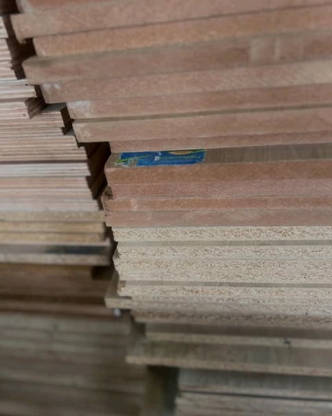 Stack of wooden boards with blue marking label on one board among the pile
