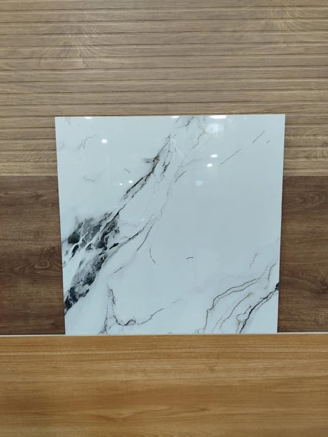 White marble tile with black veining leaning against wooden flooring