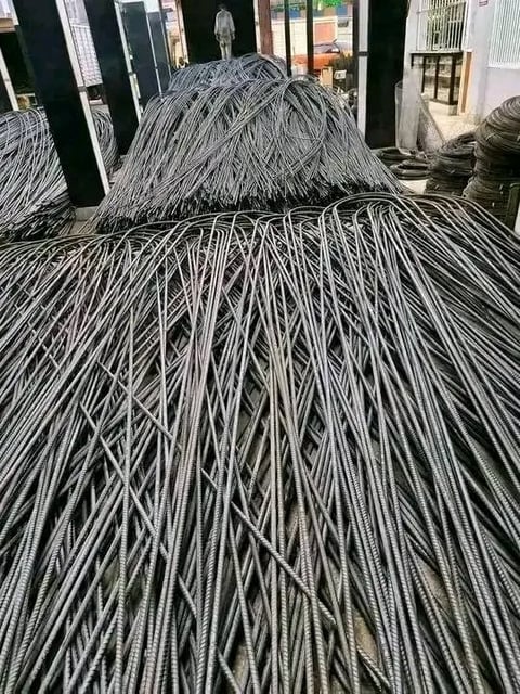 Coiled metal wire bundles stacked at an industrial facility