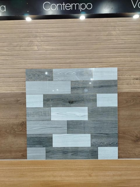 Display of mixed wood plank samples in various shades arranged in a brick pattern on showroom wall